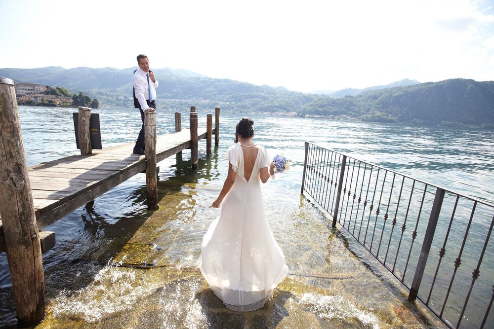 fotografia di una coppia di sposi in cui la sposa si bagna nelle acque del lago di Como.