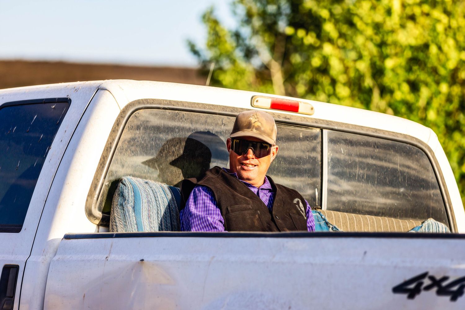 Ranch hand waiting in the back of the pcikup truck
