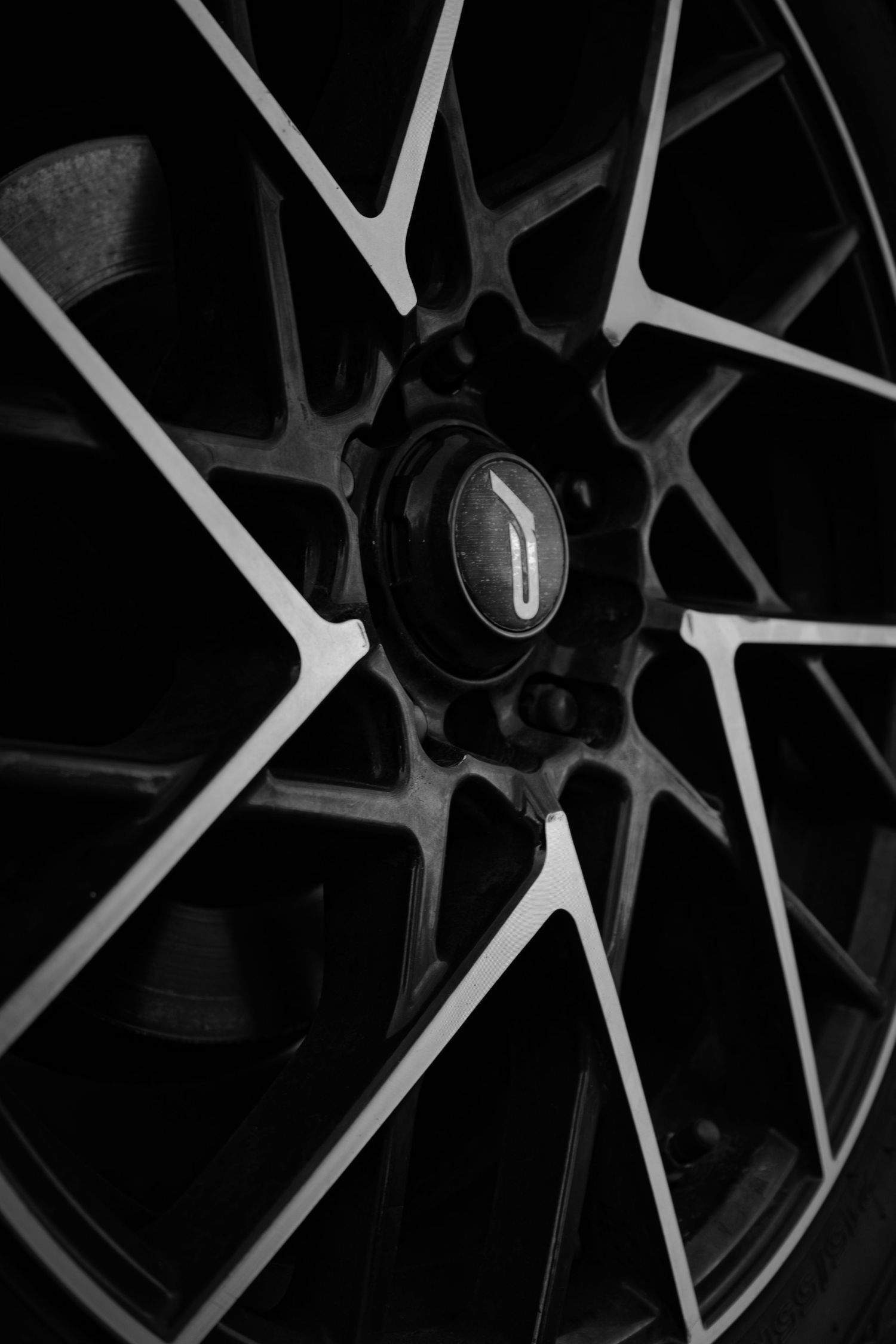 Close-up view of black and silver alloy wheel spokes with intricate geometric patterns and design details.