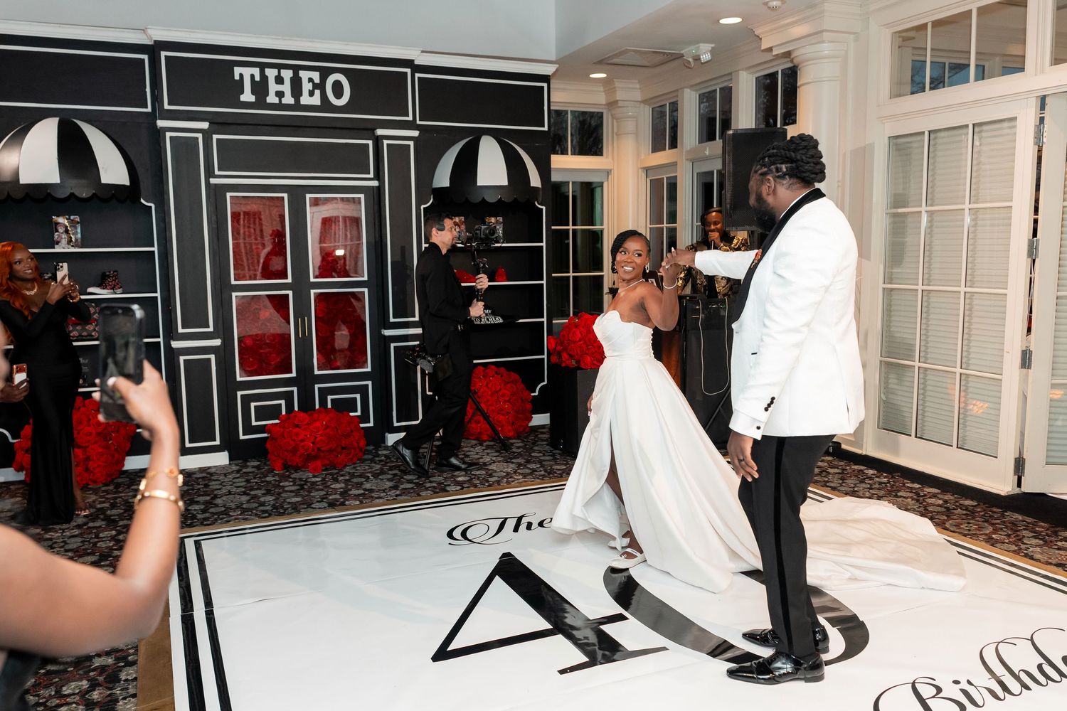 Couple dancing at elegant birthday party with THEO storefront backdrop on black and white dance floor. Deerfield Golf Club Newark De