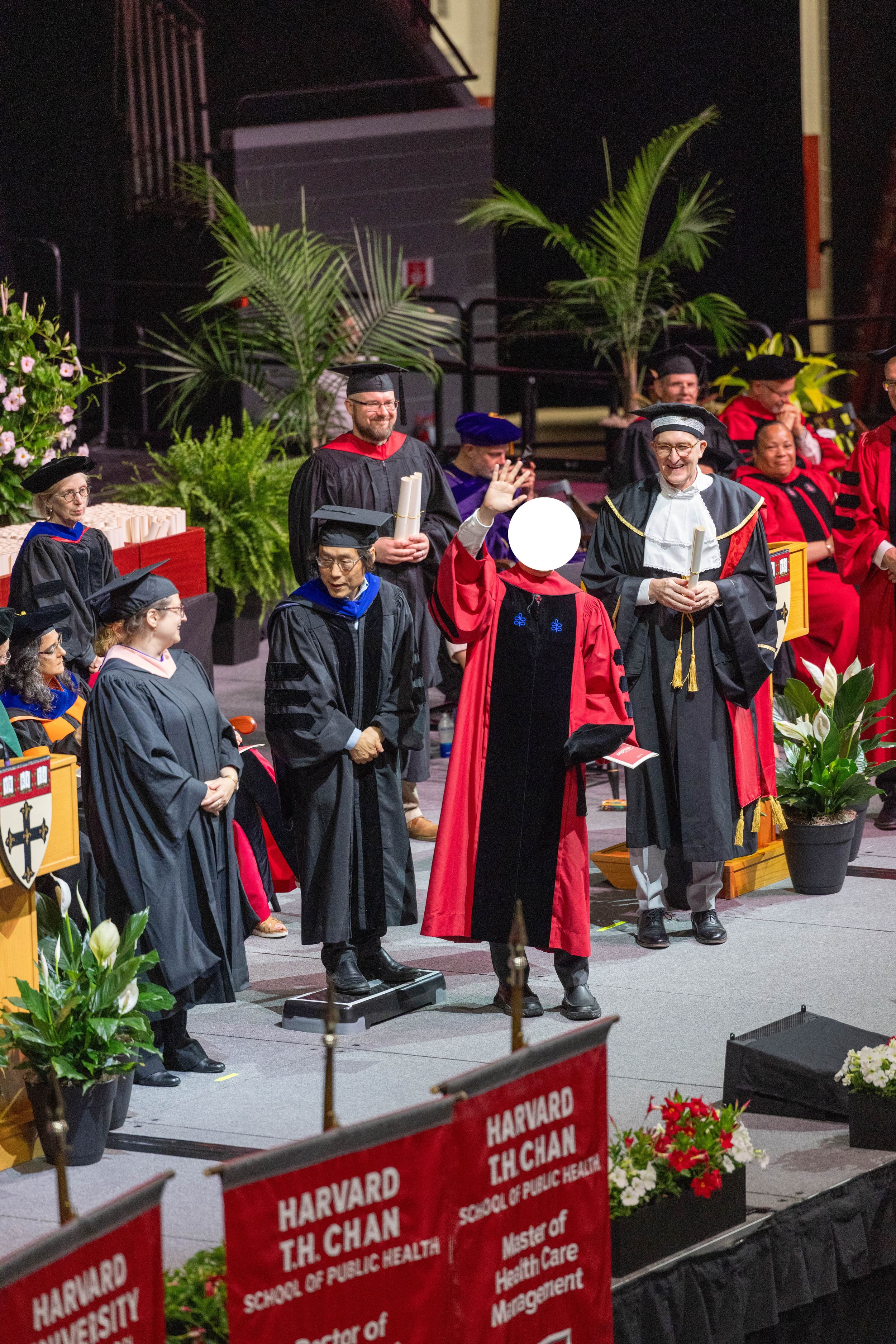 Harvard T.H. Chan School of Public Health graduation ceremony with faculty in academic regalia on stage.