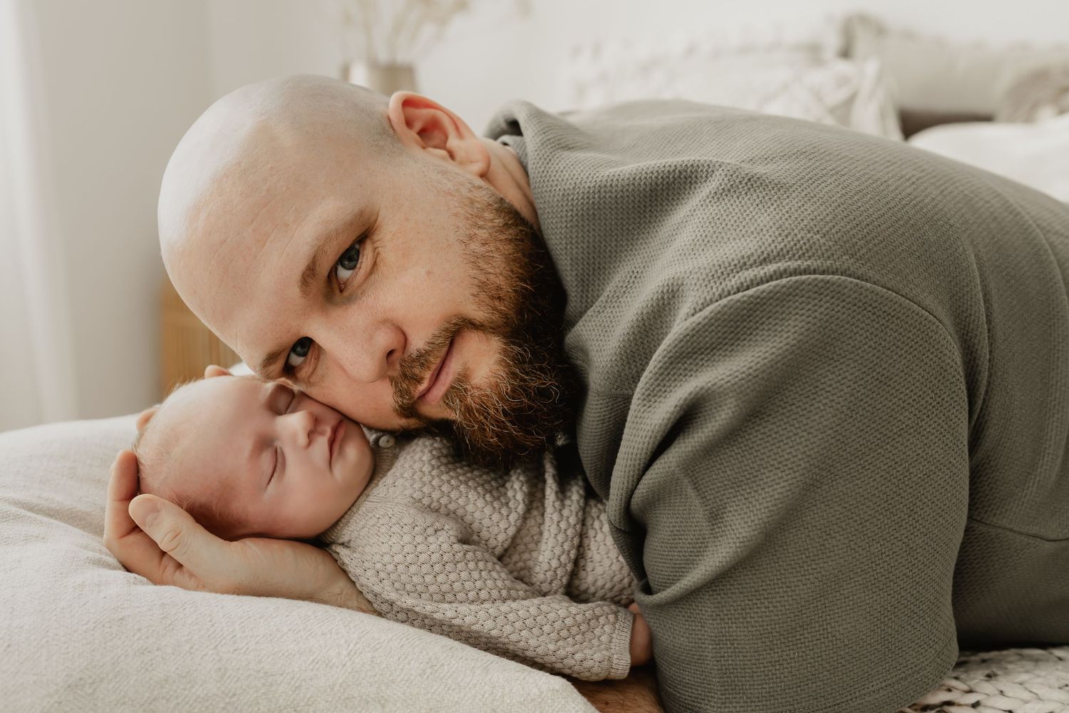 Papa kuschelt mit seinem schlafenden Baby beim Fotoshooting im Fotostudio Niederösterreich
