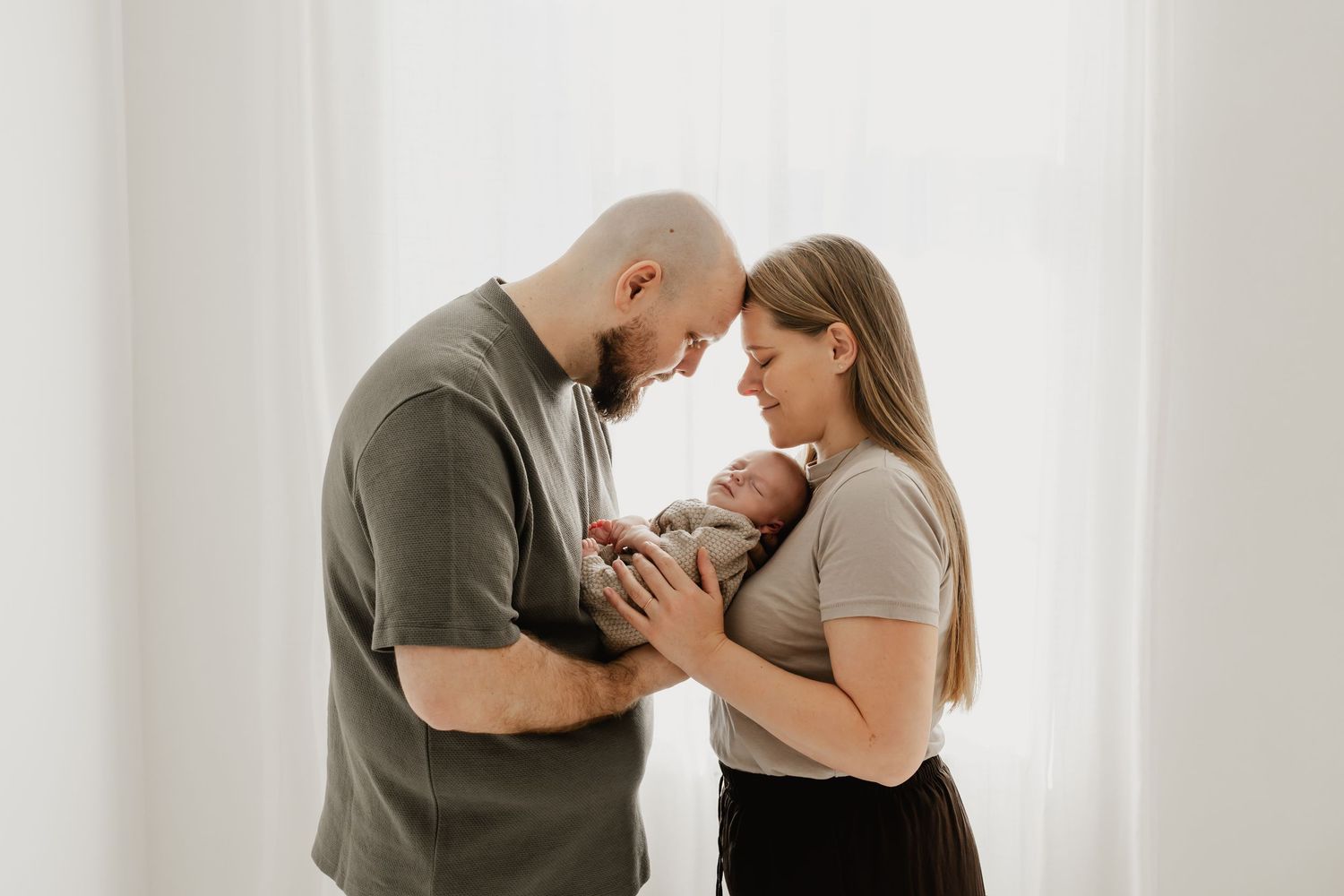 Eltern mit Neugeborenem fotografiert im Gegenlicht im Fotostudio Stockerau Niederösterreich