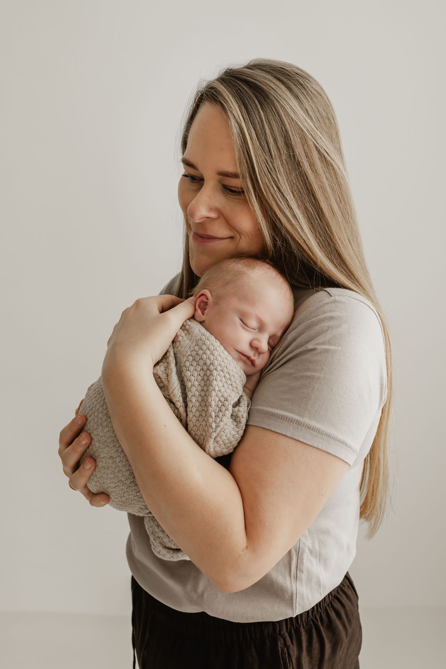 Mama mit schlafendem Baby im Arm beim Babyfotograf Niederösterreich