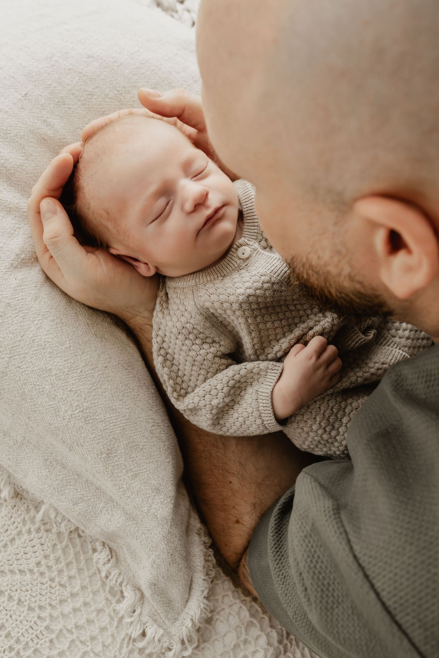 natürliches Babyfoto mit Papa beim Newbornfotoshooting Tulln Stockerau im Tageslichtatelier