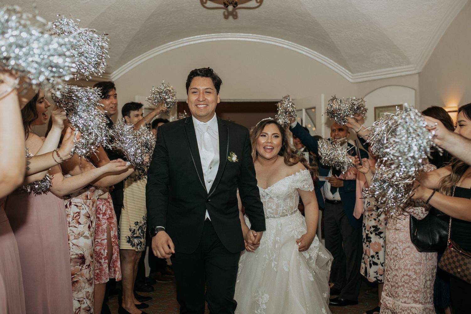 Newlywed couple walks through sparkler tunnel of guests celebrating their wedding reception at The Thursday Club.
