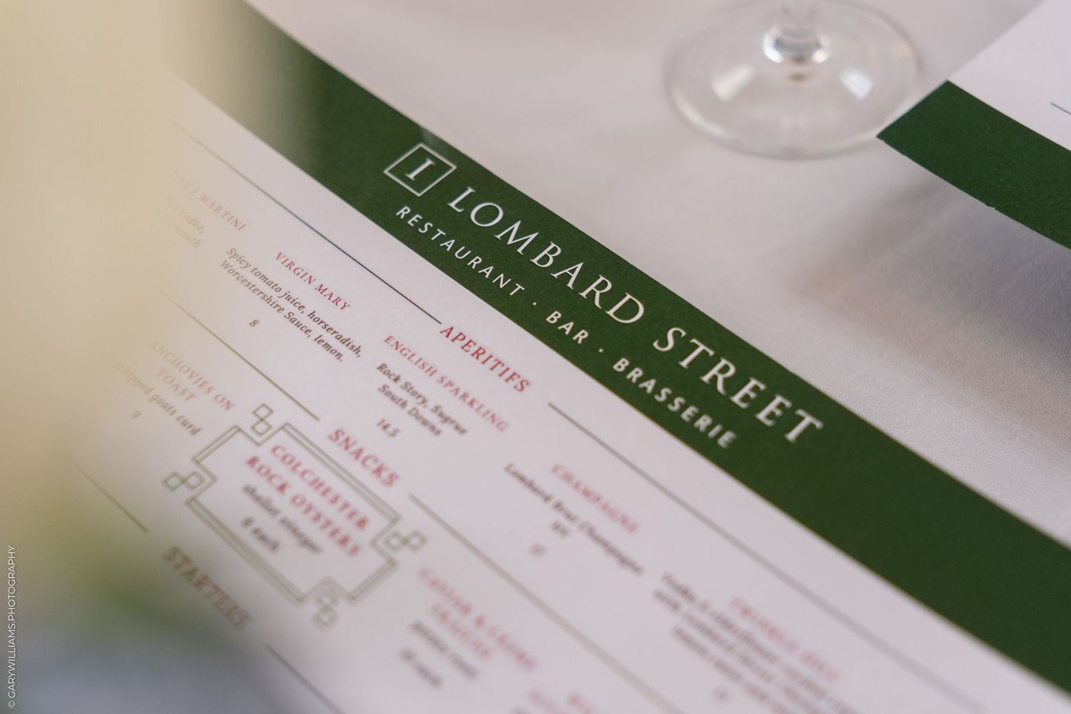 Close-up of Lombard Street Restaurant Bar Brasserie menu with wine glass in background.