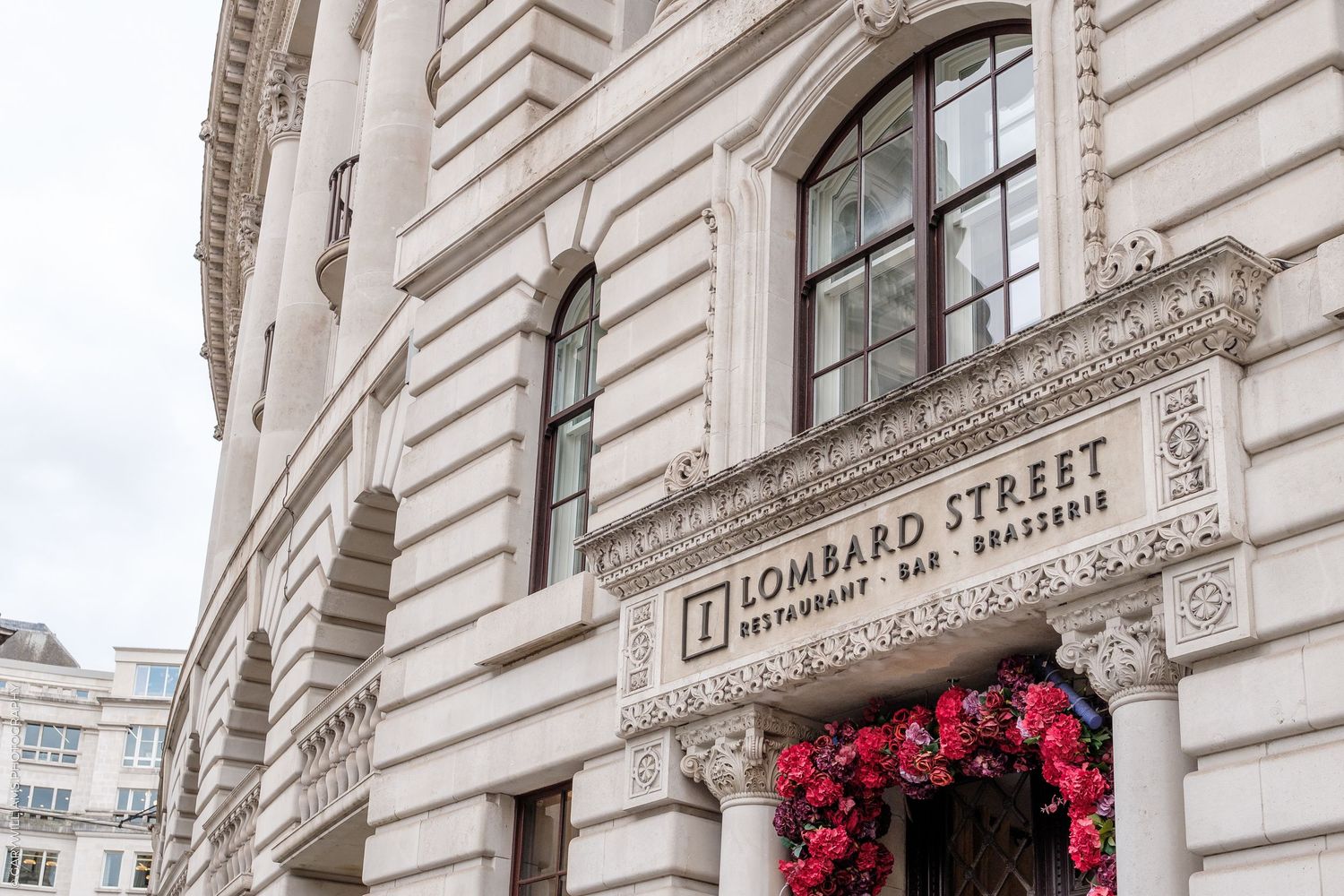 Exterior of Lombard Street Restaurant Bar Brasserie in London, featuring ornate architecture and red floral decorations.