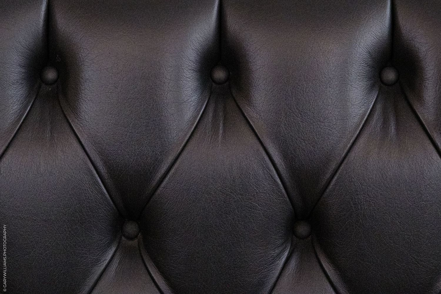 Close-up of tufted black leather upholstery with diamond pattern and button details of 1 Lombard Street