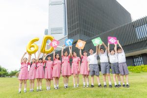 Students in pink uniforms hold colorful balloons spelling 6D outdoors near a modern building on a sunny day.身穿粉紅色制服的學生們在一棟建築附近的戶外，持拼成「6D」的氣球