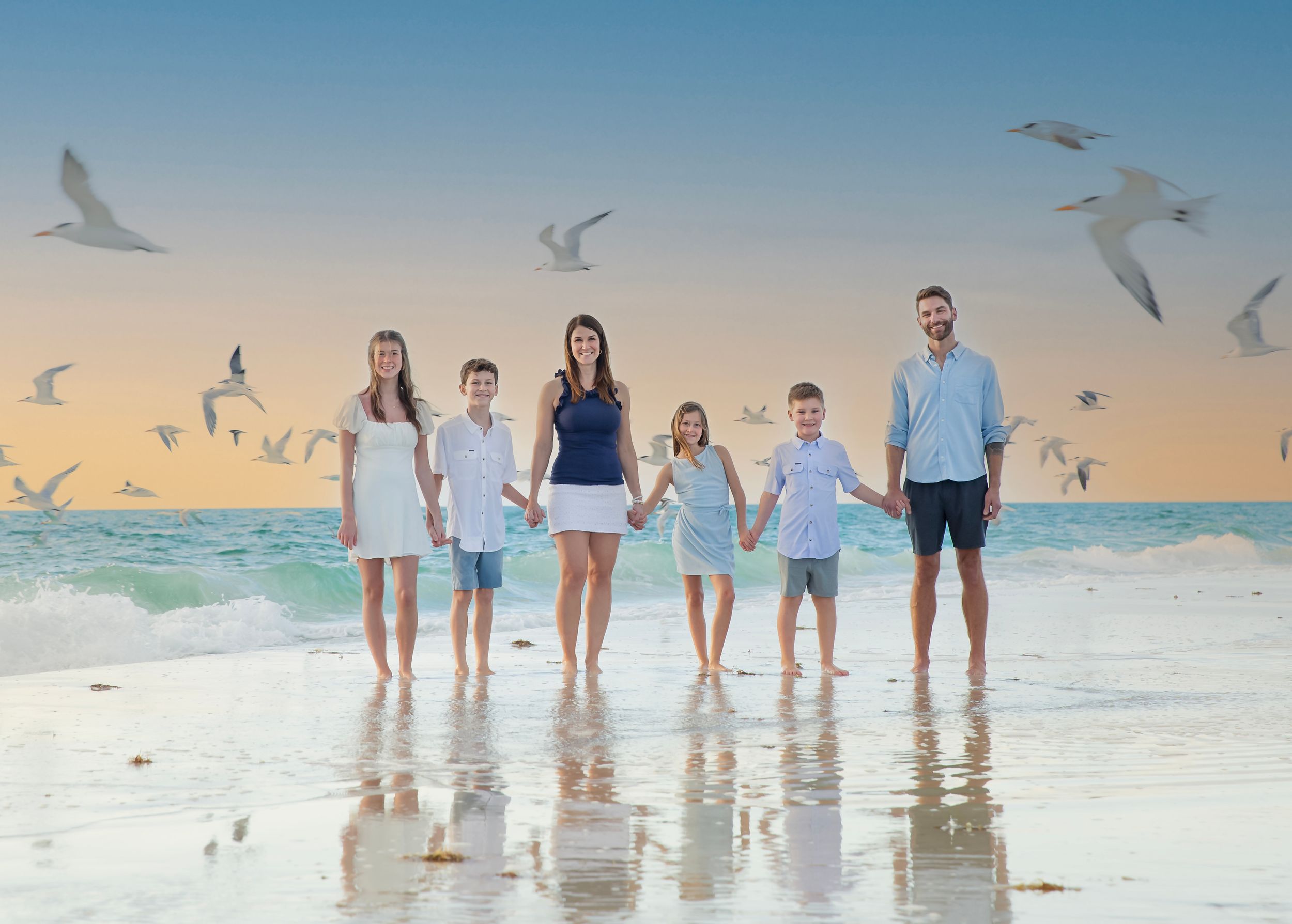 happy family beach photoshoot Longboat Key sunset white sand birds flying background natural candid moment Florida