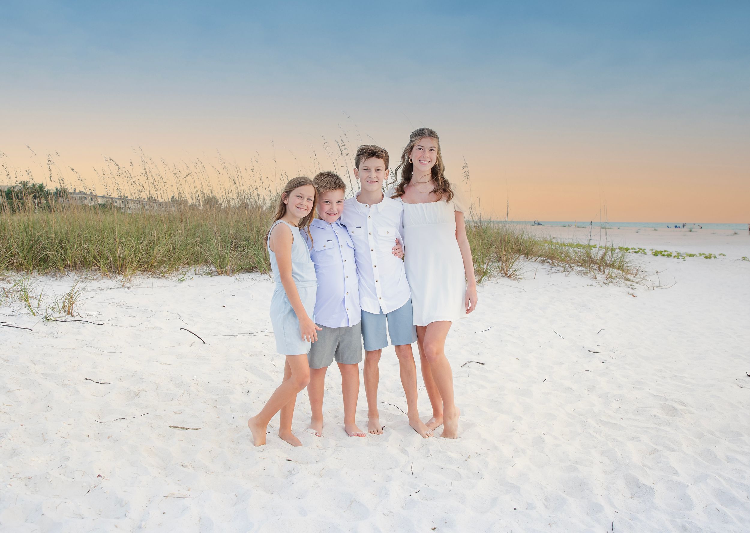 happy family beach photoshoot Longboat Key sunset white sand birds flying background natural candid moment Florida