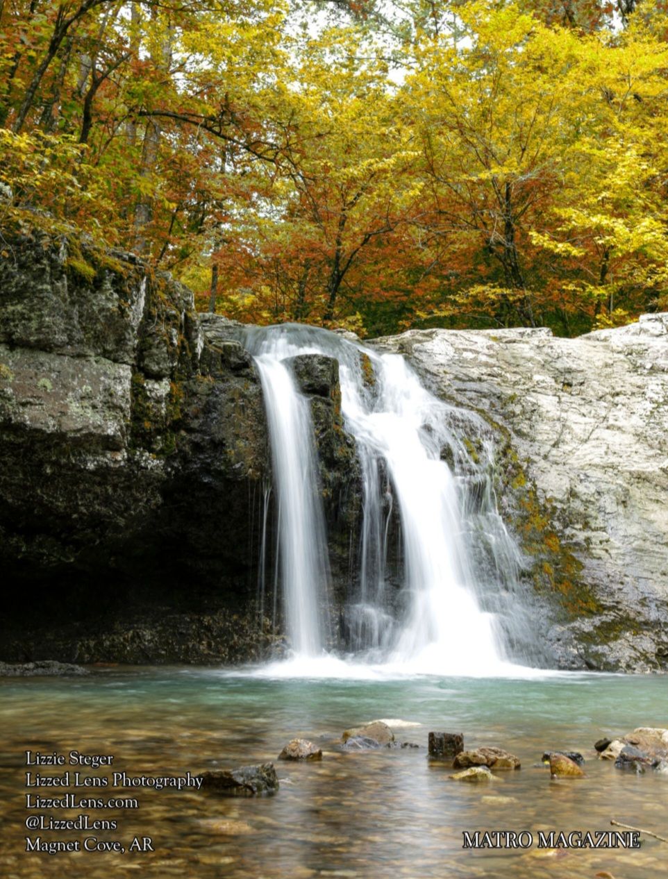 Stunning twin waterfalls cascade over rocky ledge surrounded by vibrant autumn foliage in Arkansas.