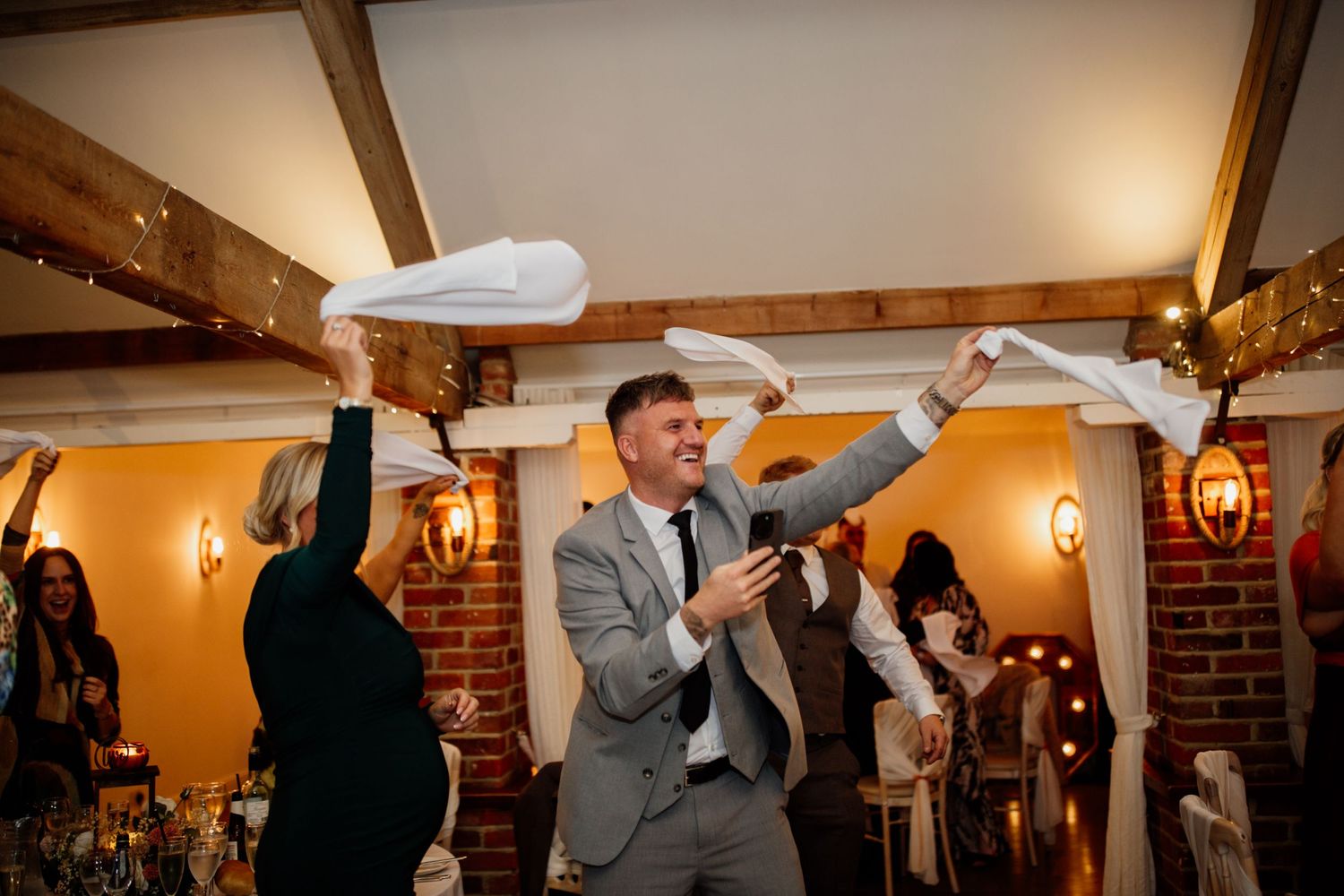 Wedding reception celebration with guests tossing white paper airplanes. Little channels Essex wedding venue