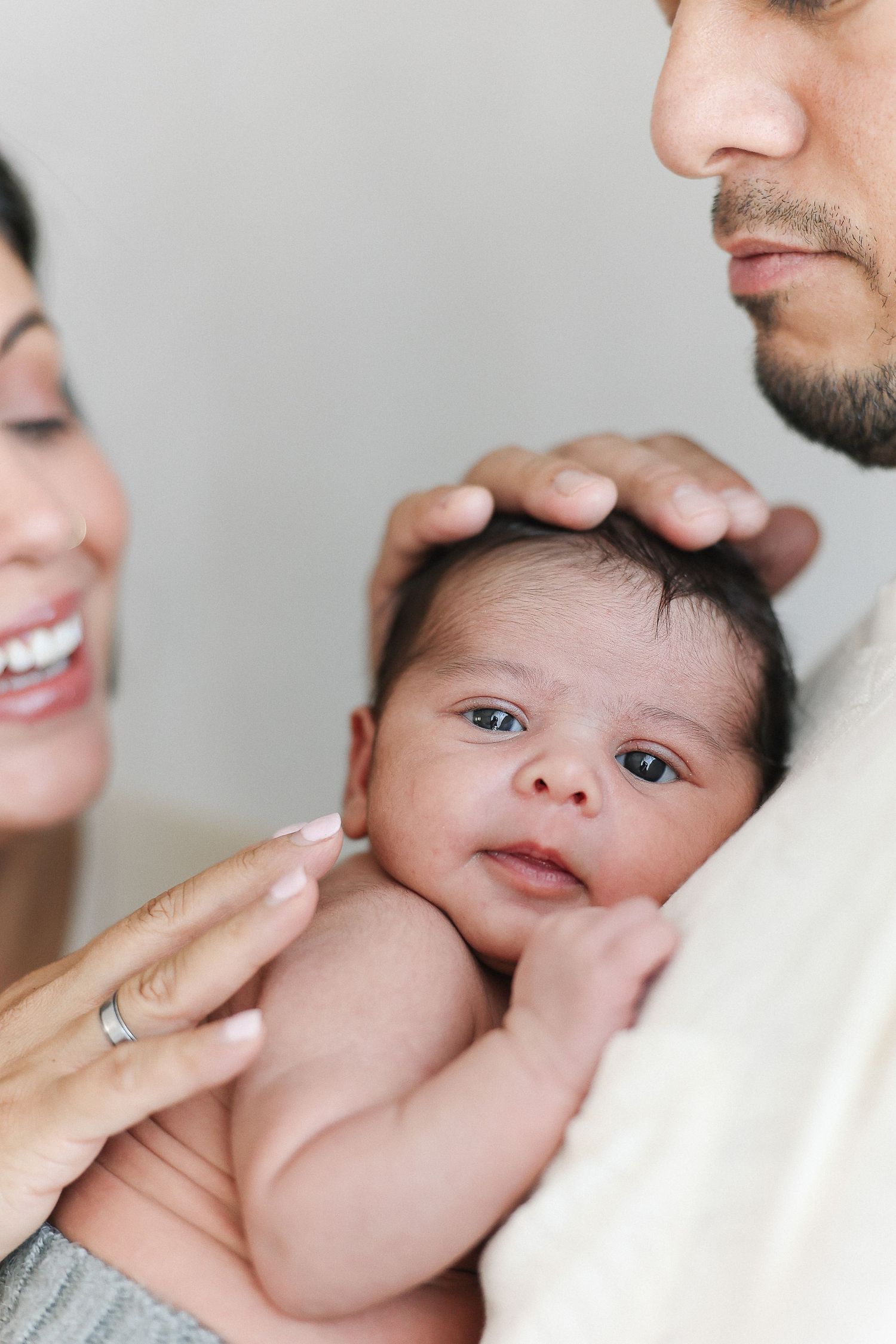 Baby snuggles with mom and dad during newborn session at Spark Studios