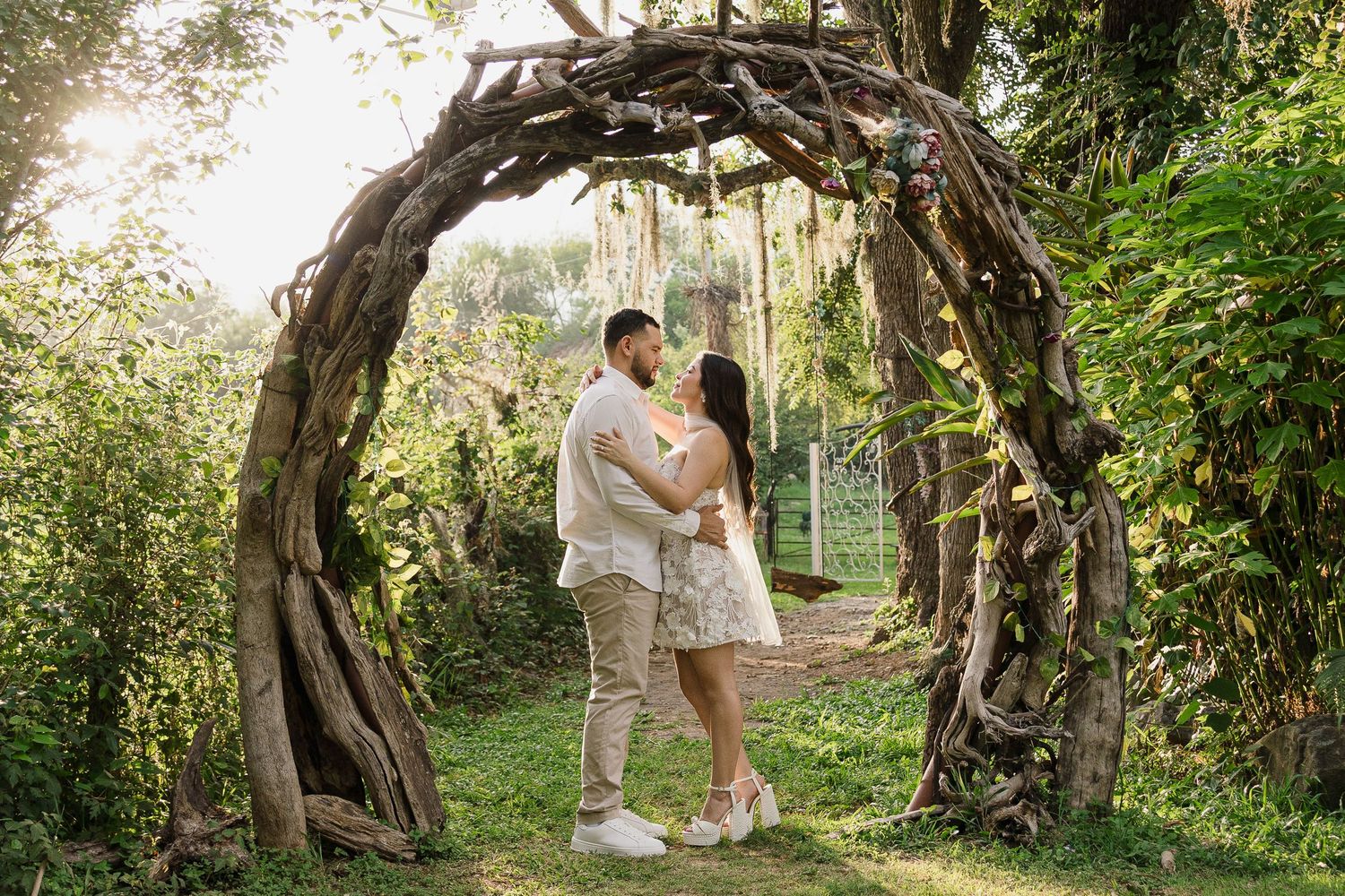Stylish couple poses against intricately carved wooden door background.