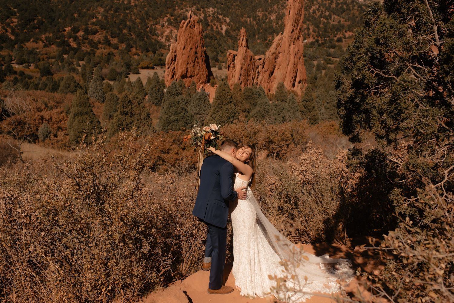 Romantic wedding portrait with towering rusty-red spires of Garden of the Gods in Colorado.