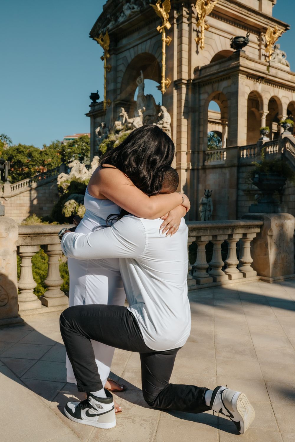 Joyful embrace after the surprise proposal during their maternity photoshoot.