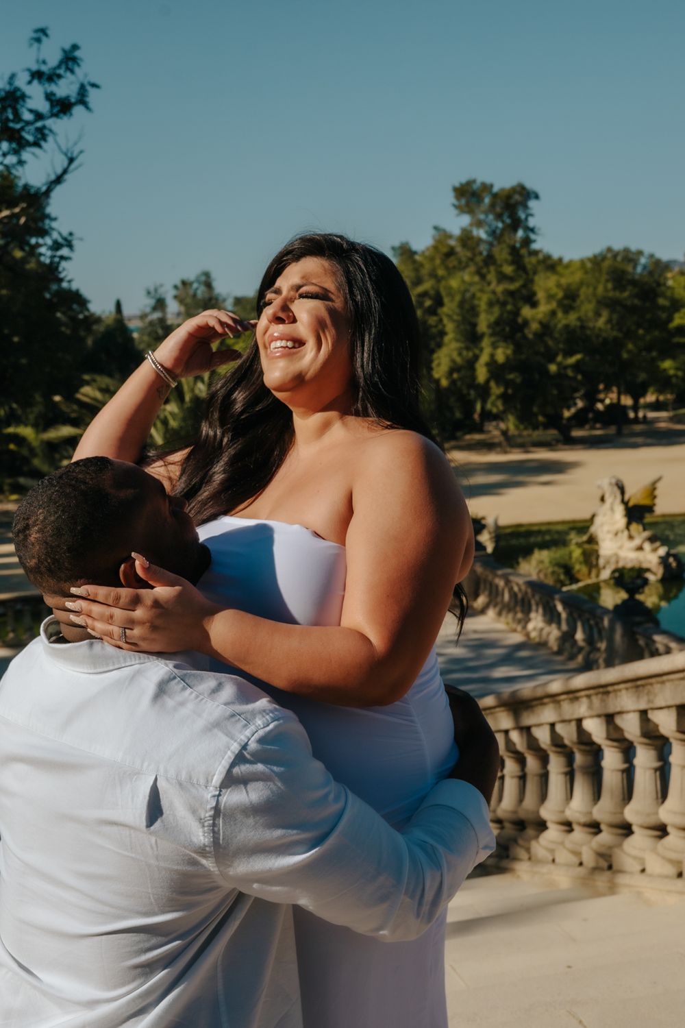 Joyful embrace after the surprise proposal during their maternity photoshoot.