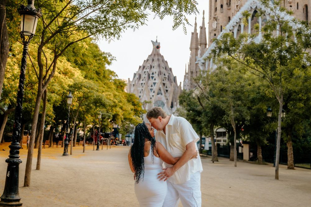 Couple laughing together as the soft sunlight illuminates Sagrada Familia.