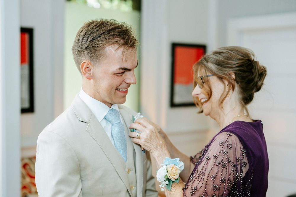 A touching moment during a wedding celebration with purple and cream colored attire.