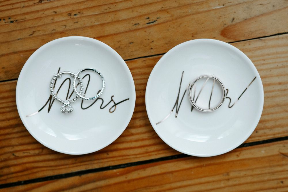 Two white decorative plates with Mr and Mrs written in elegant script on wooden table.