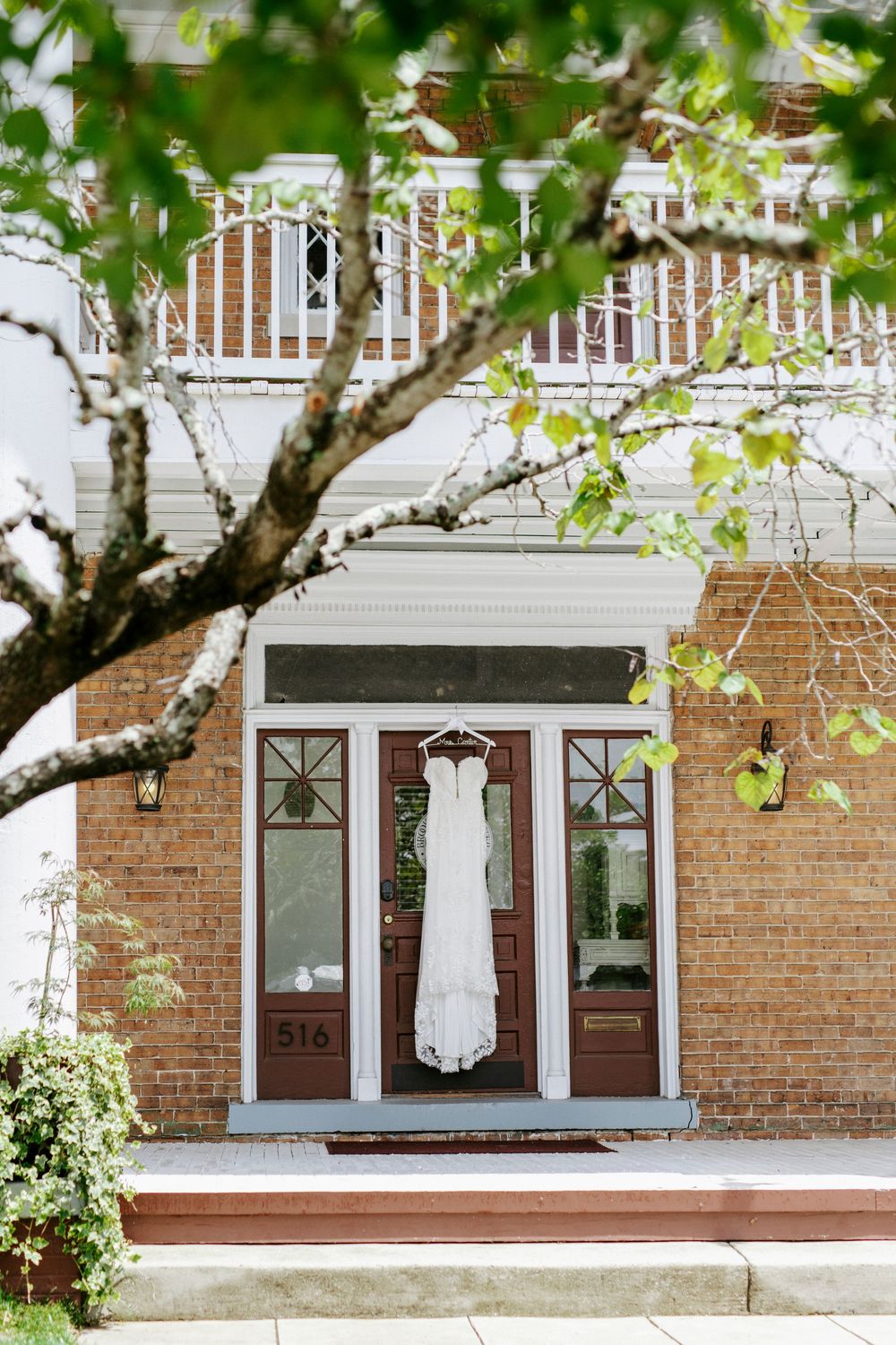 A sequence of photos showing a white wedding dress hanging outside a red brick home with white trim windows.
