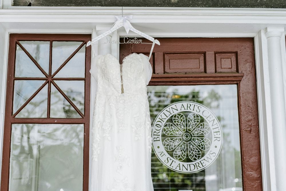 White pillars and wooden doors create a classic entrance to a wedding venue with a decorative monogram sign.