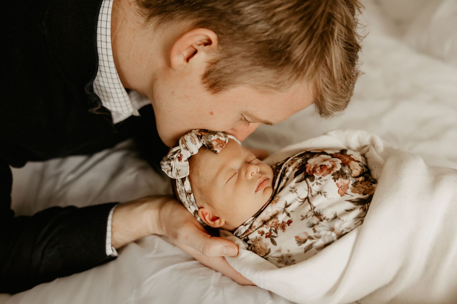 A father kisses his baby girl's head during their Honolulu Newborn session.