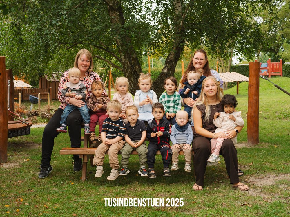 Four groups of people sit together on outdoor benches in a park or garden setting.