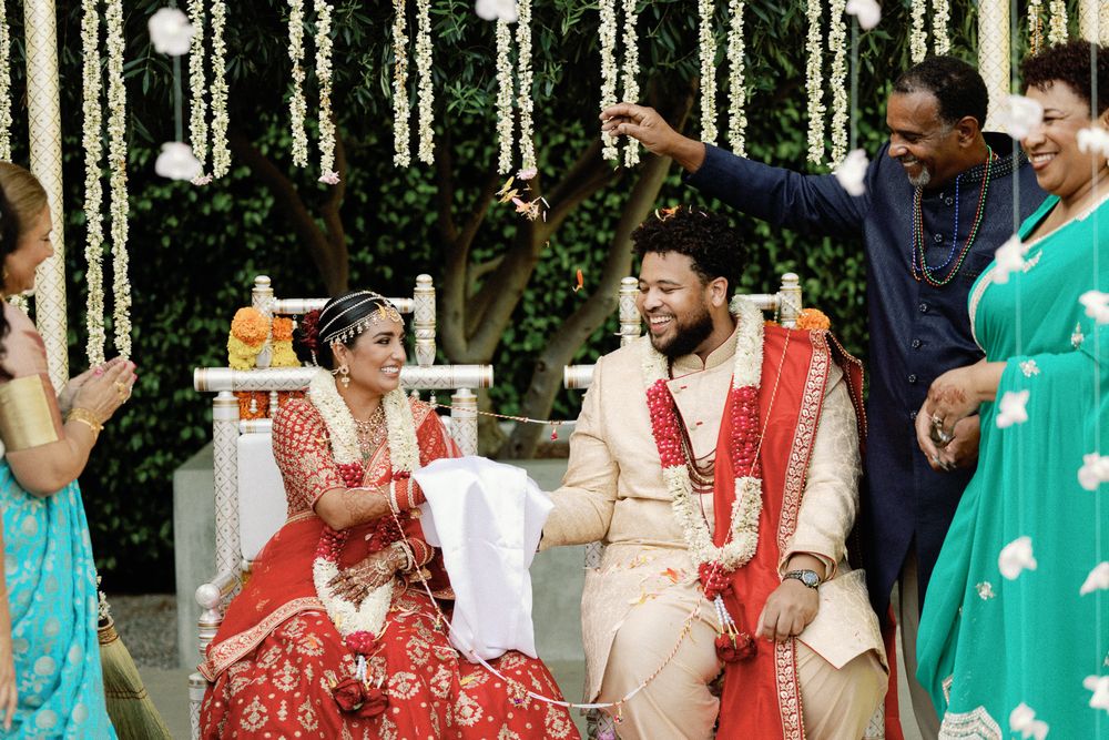Indian bride and groom seated at mandap during traditional Hindu wedding ceremony.