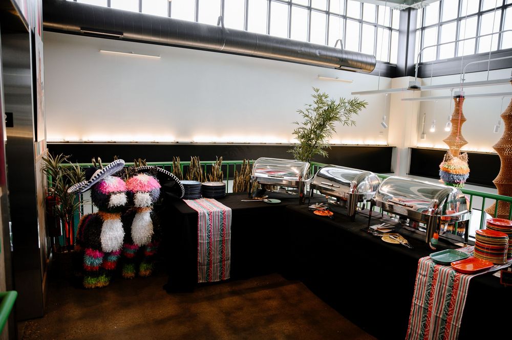Indoor exhibition space with retail displays featuring plush toys and merchandise against dark walls and industrial ceiling.
