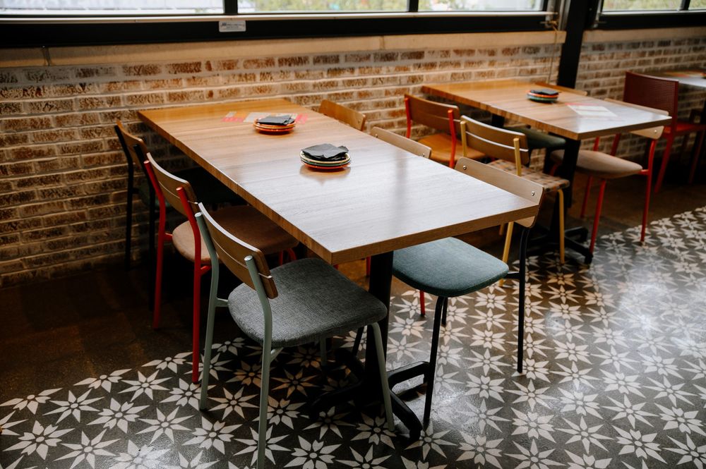 Modern restaurant interior with brick walls and geometric patterned floor tiles.
