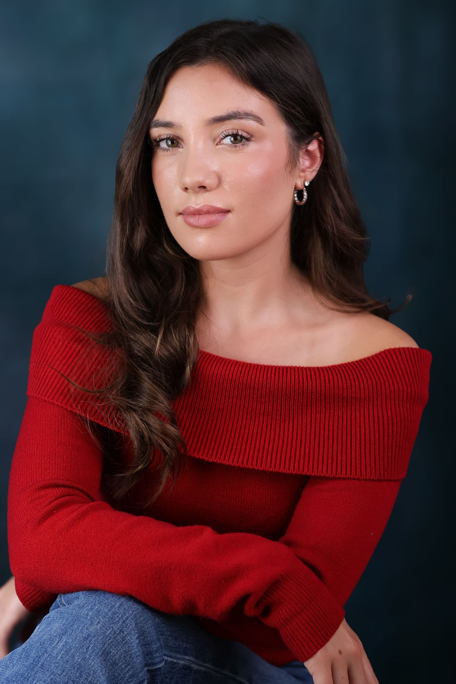 Portrait series of a person in a red sweater and dark denim against a navy studio backdrop showing different poses.