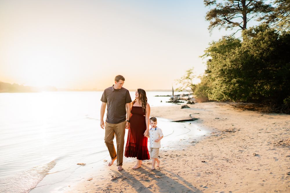 Romantic sunset photos of a couple walking on the beach with palm trees casting shadows on the white sand.