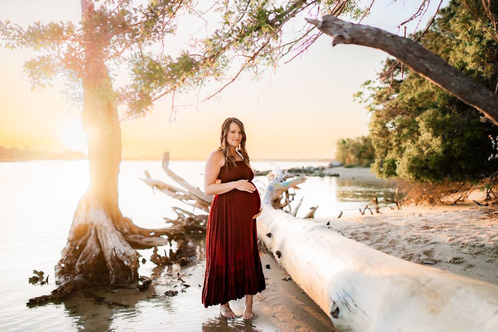 A scenic golden beach photoshoot at sunset with figure standing near ocean waves and palm trees.