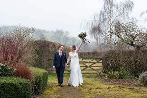 A couple walks along a scenic path through a rustic countryside setting on an overcast winter day.