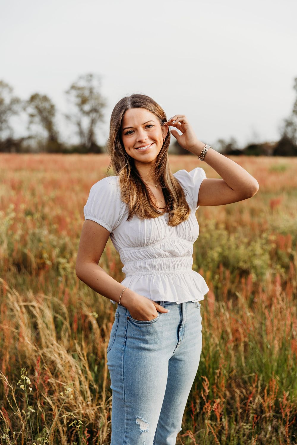 A series of photos showing someone posing in a white top and jeans in a rustic field at sunset.
