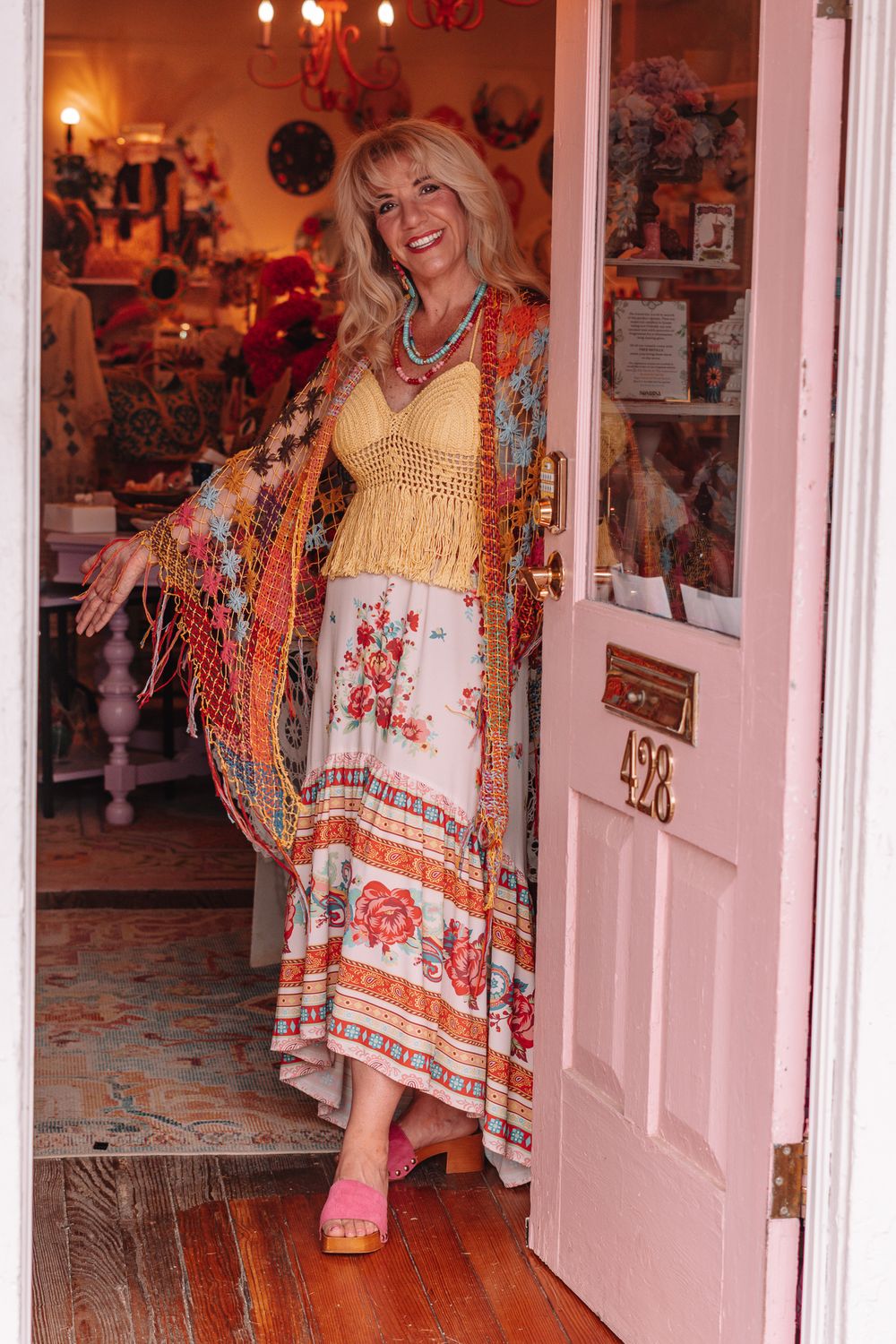 Interior of boutique with floral dresses displayed and warm lighting.
