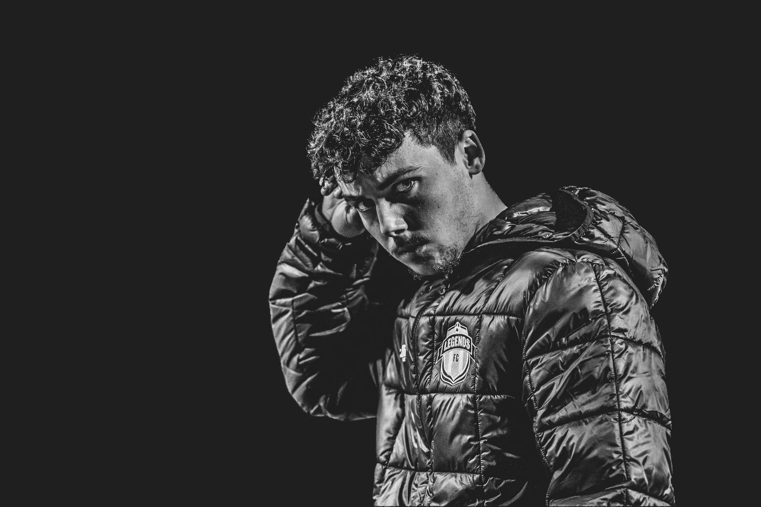 Person in dark puffy jacket shown in dramatic black and white portrait series.