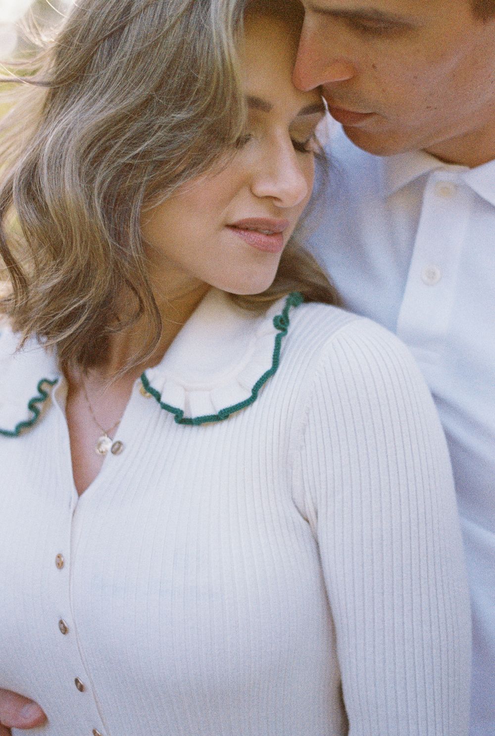A tender romantic close-up series in muted tones shows a couple in white sharing intimate moments.