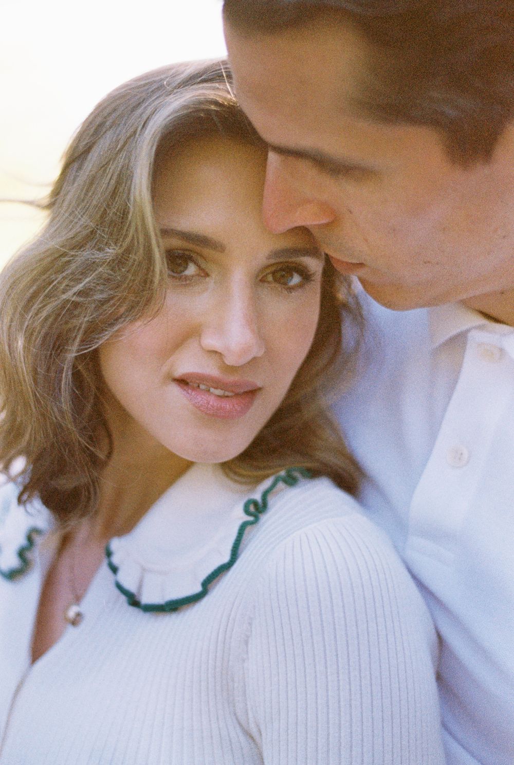 Close-up candid shots of a couple in a cozy white knit sweater sharing intimate moments together.