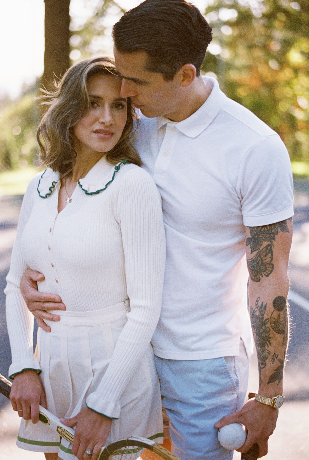 A romantic outdoor couple photo series in white outfits showing tender moments against a sunlit natural background.