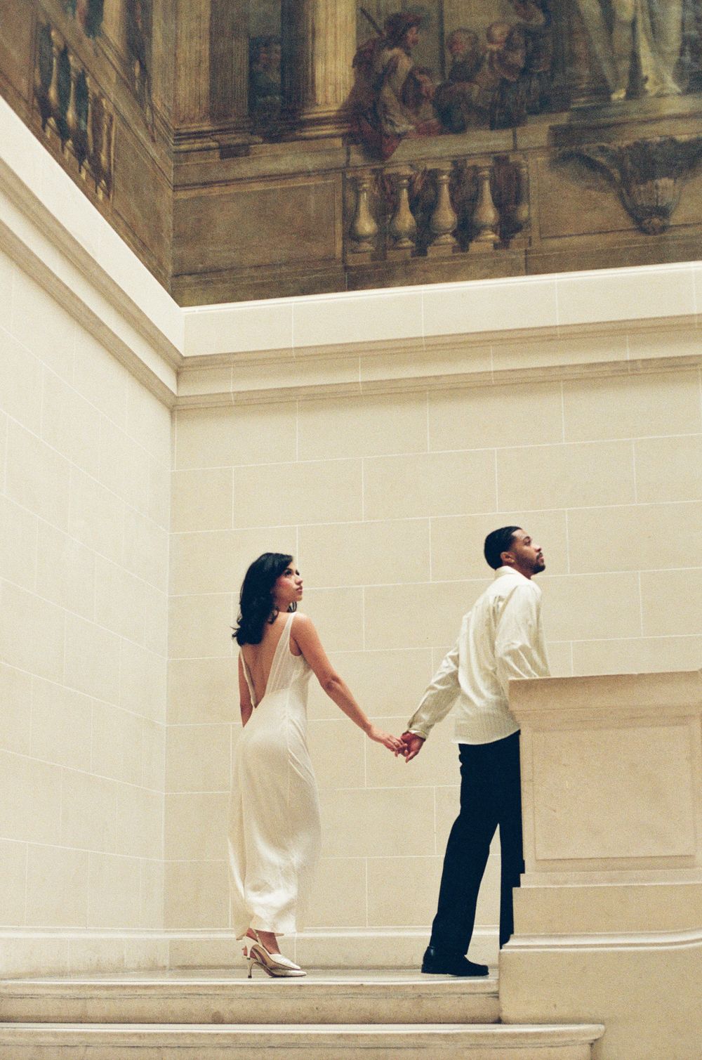An artistic triptych photo sequence shows a couple a white classical architectural wall. Paris film photograph