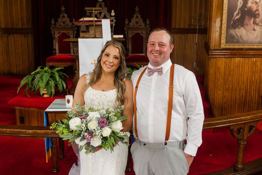 A couple poses together at a rustic wooden venue with romantic lighting and decor.