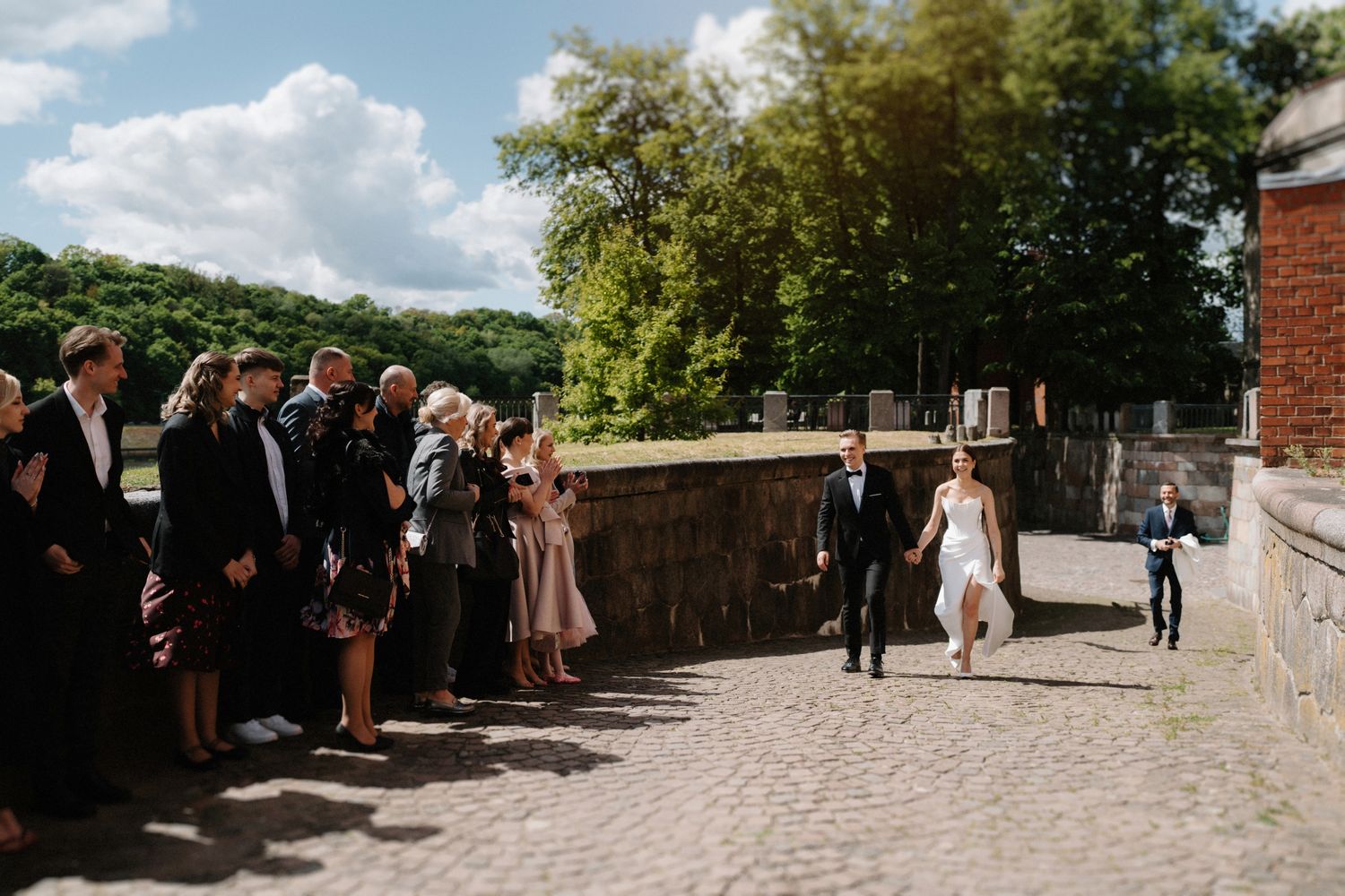 Outdoor wedding venue with brick pathways and guests gathering in the courtyard.