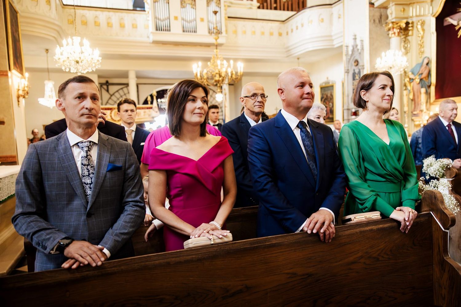 Rodzina i goście w ławkach kościelnych podczas ślubu