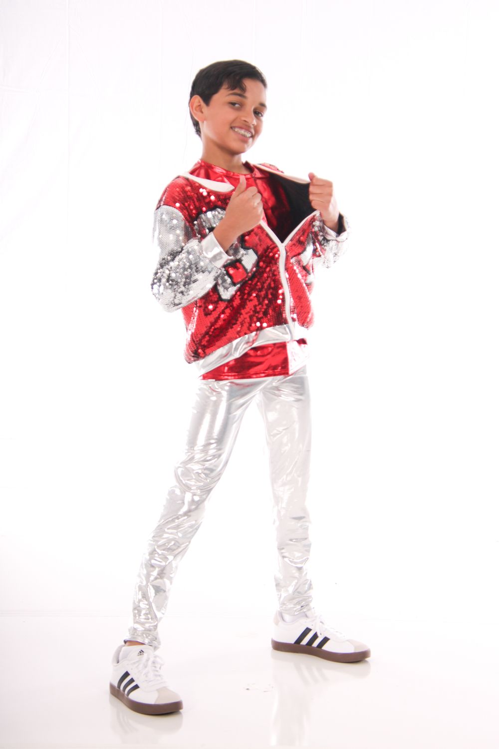 Dancer in red and silver costume performs hip hop moves on white background.