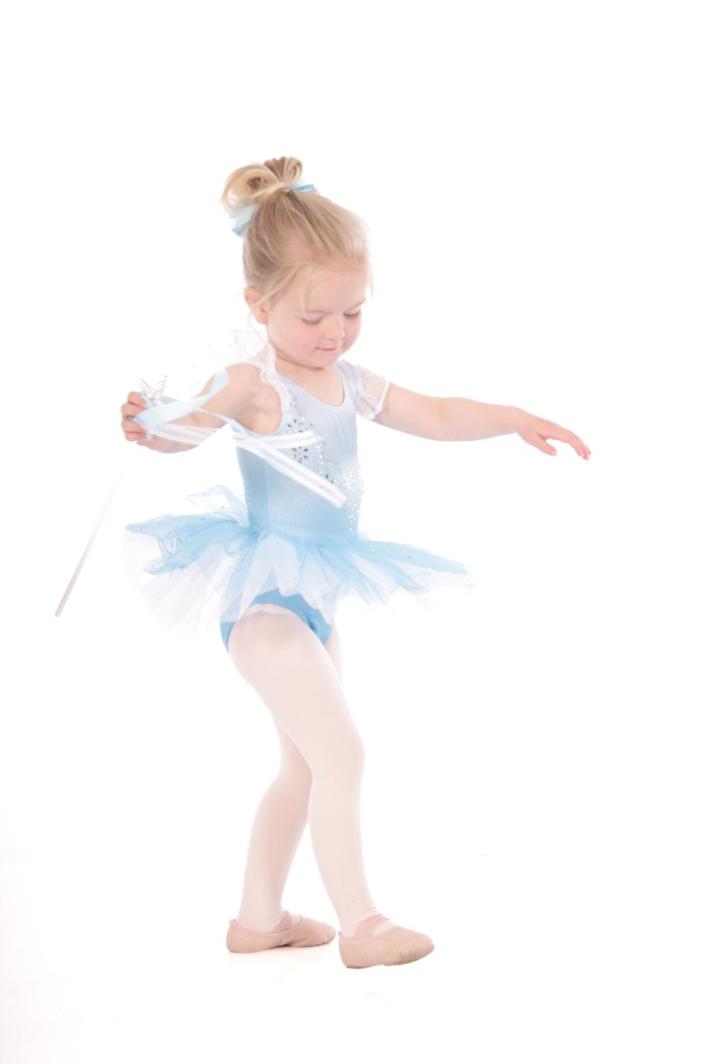 Ballet dancer in light blue tutu practices dance positions.