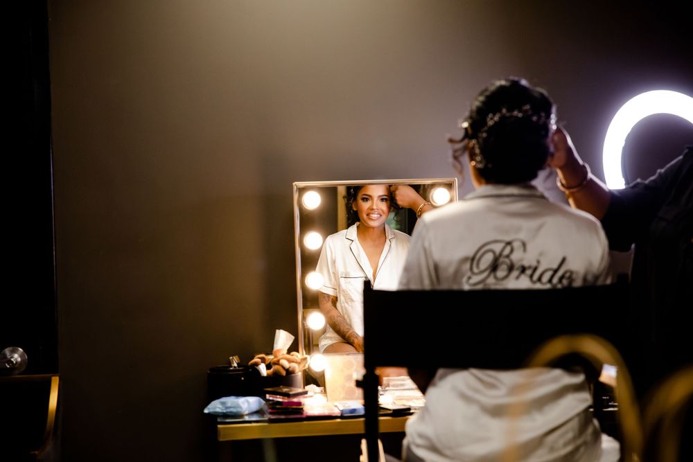 Getting ready scene reflected in a mirror with dramatic lighting and a robe visible.